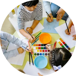 Learning Made fun Children drawing and painting at a table, representing The Art of Living’s ART Excel life skills.