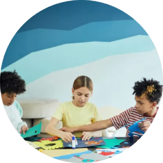 Social Skills Three children engaged in arts and crafts at a table, fostering creativity and focus.