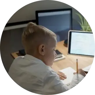 Better learning Child with blonde hair writing on paper at a desk.