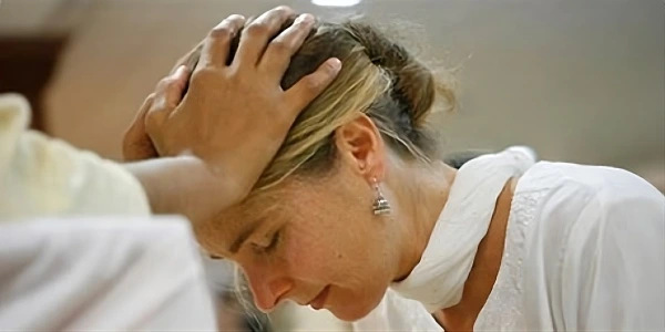Blessings - Journey of Grace & Transformation Person receiving healing energy during Art of Living Blessings program, showing moment of deep spiritual connection